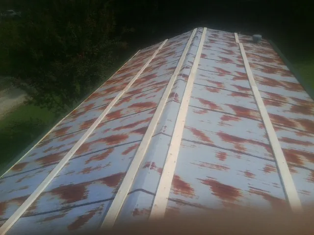 Rusted metal roof panels with new wood purlins before replacement — Storm Damage Roof Repair in Lookeba by Roofing Brothers